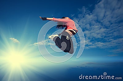 Sport woman jumping and fly over sky and sun Stock Photo