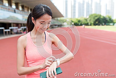 Sport woman using wearable smart watch in sport stadium Stock Photo