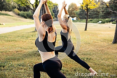 Sport women doing yoga outside in morning. Fitness girls relax in park Stock Photo