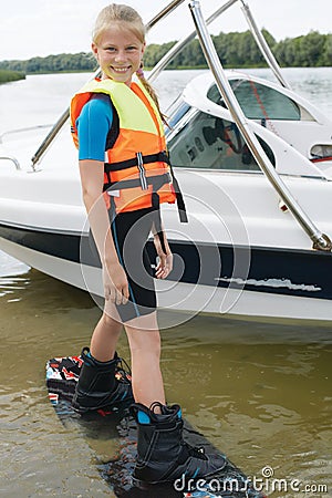 Sportin child riding on a wakeboard on the lake. Stock Photo