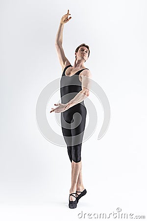 Sportive Caucasian Male Ballet Dancer Flexible Athletic Man Posing in Black Tights in Ballanced Dance Pose With Hands Lifted Stock Photo