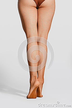 Sportive female legs in fishnet tights Stock Photo
