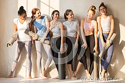 Sportive multiracial girls talk laughing waiting for yoga class Stock Photo