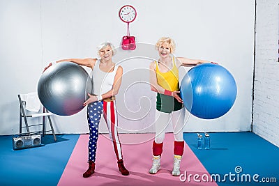 sportive senior ladies holding fitness balls and smiling at camera Stock Photo