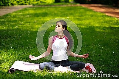 Sportive young woman relaxing in sunshine, doing yoga exercises Stock Photo