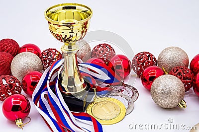 Sports awards and new year`s toys, medals and cups, red Christmas balls, winter competitions, new year`s holidays Stock Photo