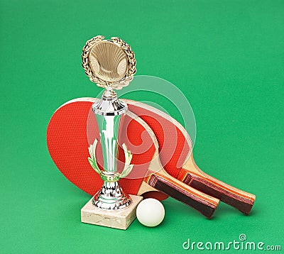 Sports awards and tennis racquets on green table Stock Photo