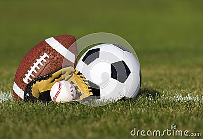 Sports balls on the field with yard line. Soccer ball, American football and Baseball in yellow glove on green grass Stock Photo