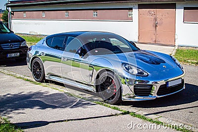 Expensive luxury sports car with shiny chrome color wrap foil parked on the street. Editorial Stock Photo