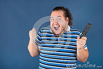 Sports fan with a television remote control Stock Photo