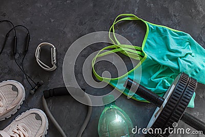 Sports flatlay composition, trendy white sneakers, sport watch, fitness chest expander, ab wheel for abdominal training Stock Photo