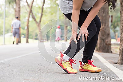 Sports injury. Cramp. Woman holding sore leg muscle while joggin Stock Photo