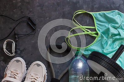 Sports flatlay composition, trendy white sneakers, sport watch, fitness chest expander, ab wheel for abdominal training Stock Photo