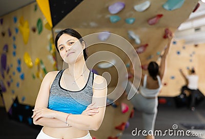 Sports positive woman climber on background of climbing wall Stock Photo
