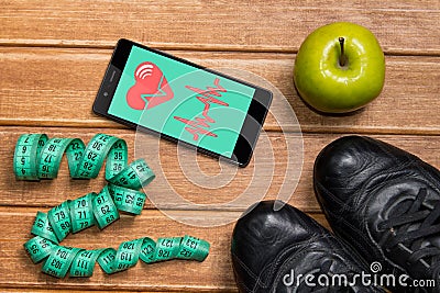 Sports shoes , Apple , measuring tape and a phone with health card on a wooden background. Mobile app health sensor for measuring Stock Photo