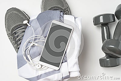 Sports stuff and a mock up mobile phone. Gym stuff, mobile phone and blank space for exercise plan on white background Stock Photo