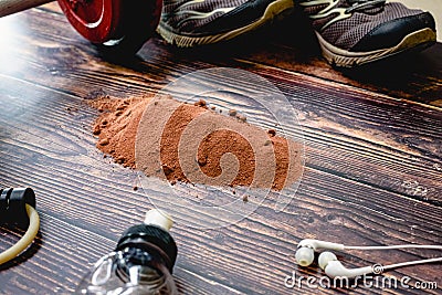 Sports supplement based on whey, protein and carbohydrates with cocoa flavor, background with fitness accessories Stock Photo