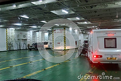 Car towing a caravan maneuvering on the deck of a car ferry Editorial Stock Photo