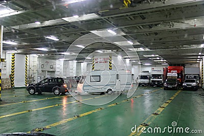 Car towing a caravan maneuvering on the deck of a car ferry Editorial Stock Photo