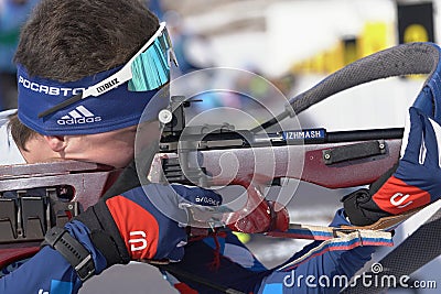 Sportsman biathlete rifle shooting, aiming, reloading rifle in prone position. Biathlete Amirbekov Artem in shooting range. Junior Editorial Stock Photo