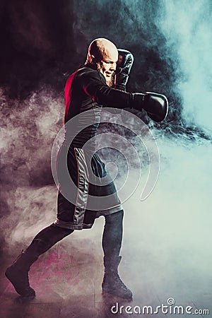 Sportsman boxer fighting on black background with smoke. Boxing sport concept Stock Photo