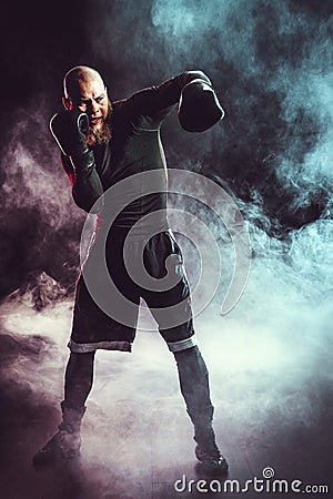 Sportsman boxer fighting on black background with smoke. Boxing sport concept Stock Photo