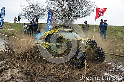 Sportsman on BRP buggy drives splashing in dirt and water at Mud Racing contest. ATV SSV Editorial Stock Photo