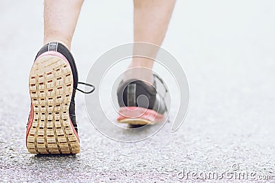 Sportsman runner feet running on road. close up on shoe behind of a man running fitness Stock Photo