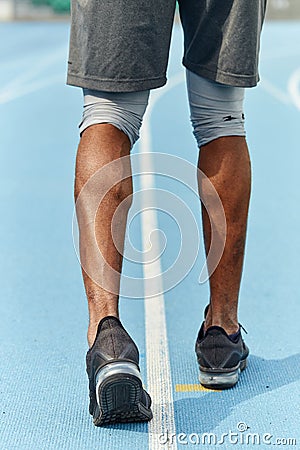 Sportsman`s muscual legs, athlete walking in the stadium Stock Photo