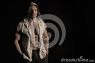 Sportsman show biceps and triceps in sleeveless shirt. Man athlete wear hood. Bodybuilder with fit torso muscles. Sport Stock Photo