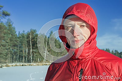 Sportsman in snowy winter outdoor landscape wearing red protective nylon jacket Stock Photo