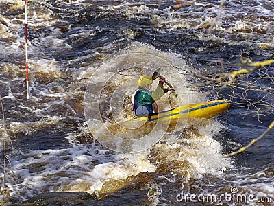 Sportsman on a sports kayak rowing on a raging river. Editorial Stock Photo
