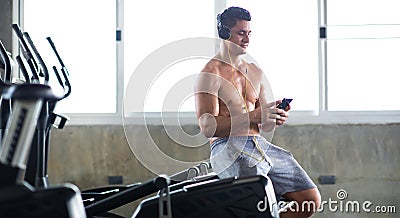 Sportsman taking a break after training at the gym sitting and drinking water at sport club. Fitness Healthy lifestye and Stock Photo