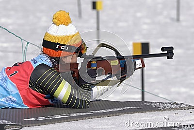 Sportswoman biathlete aiming, rifle shooting prone position. South Korea biathlete Lee Hyunju in shooting range. Junior biathlon Editorial Stock Photo