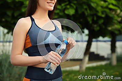 Sportswoman with bottle of water outdoors Stock Photo