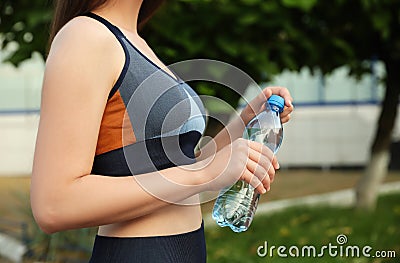 Sportswoman with bottle of water outdoors Stock Photo