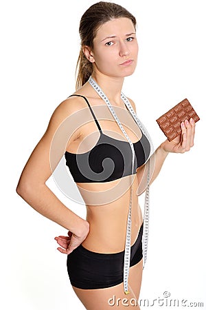Sportswoman with chocolate. The problem and the temptation while Stock Photo