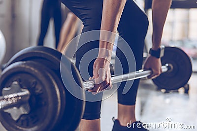 Sportswoman lifting barbell at gym workout Stock Photo