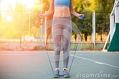 Sportswoman with skipping rope standing on stadium Stock Photo