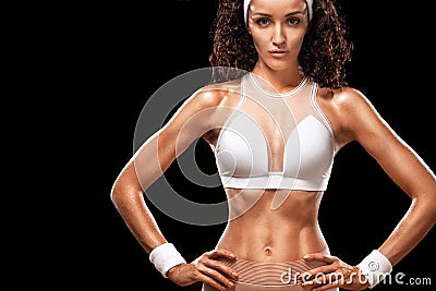 Sporty beautiful woman with curly hair makes fitness exercising at black background to stay fit Stock Photo