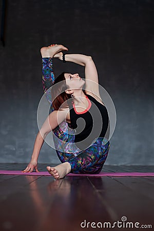 Sporty young woman doing Parivritta Kraunchasana, Revolved Heron, Compass Pose Stock Photo