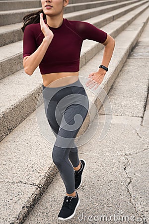 Sporty brunette running next to stairs Stock Photo