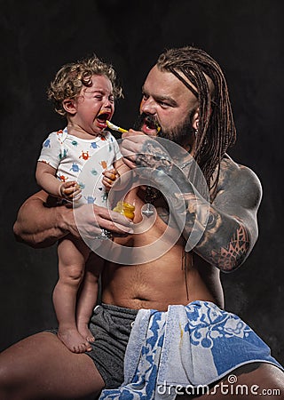 Sporty brutal man holds in arms a little baby Stock Photo