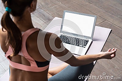 Sporty calm woman sit on mat watch online yoga class on laptop mock up screen Stock Photo