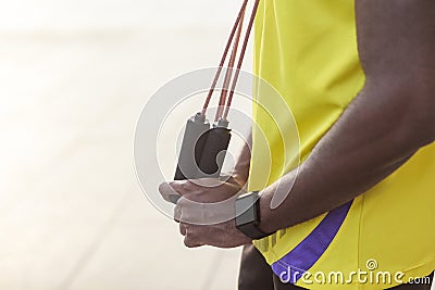 Sporty detail. dark skin man holding jump rope Stock Photo