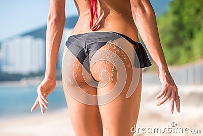 Sporty female in with two sand hand prints. Cropped image of young woman standing her back turned to camera wearing Stock Photo