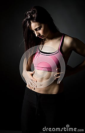 Sporty Female Holding her Stomach Stock Photo