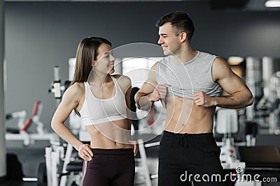 Sporty fitness couple showing in gym. Beautiful athletic man and woman, muscular torso abs Stock Photo