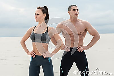 Sporty fitness couple showing muscle outdoors. Beautiful athletic man and woman, muscular torso abs Stock Photo