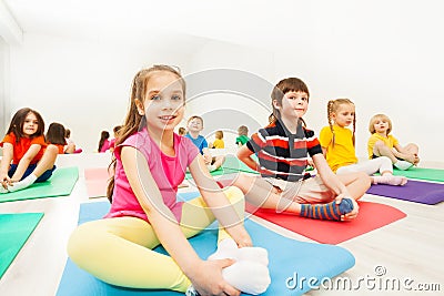 Sporty girl doing butterfly stretch on yoga mat Stock Photo